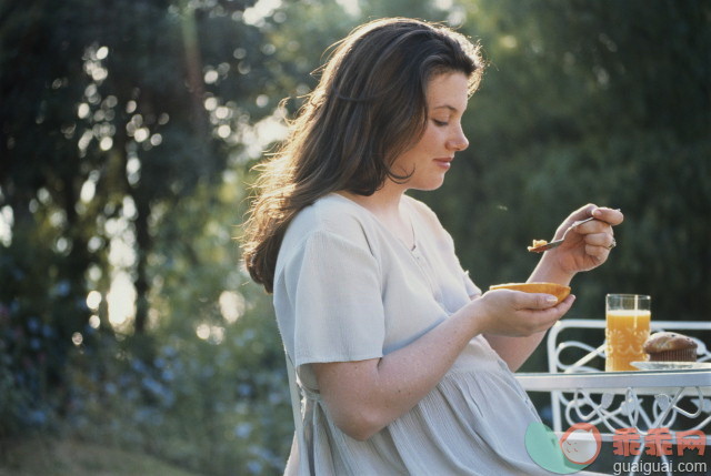 饮食,健康食物,人生大事,摄影,肖像_879144-001_Pregnant woman eating papaya, muffin, and orange juice_创意图片_Getty Images China