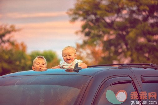 人,运输,户外,人的头部,白人_479361609_Brother and sister peeking out of car sunroof_创意图片_Getty Images China
