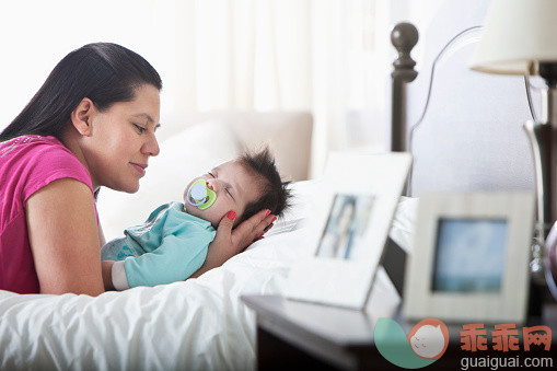 人,床,生活方式,2到5个月,室内_557476605_Hispanic mother admiring sleeping baby boy on bed_创意图片_Getty Images China