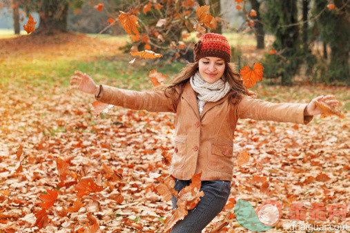 橙色,公园,人,活动,休闲装_165652938_young woman playing with autumn leaves_创意图片_Getty Images China