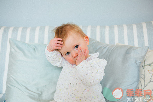 人,沙发,蓝色眼睛,深情的,金色头发_554770675_One year old baby girl with a cold, sitting._创意图片_Getty Images China