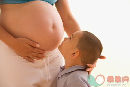 摄影,家庭,白色,白色背景,父母_57012595_Young boy examining his pregnant mother's belly_创意图片_Getty Images China