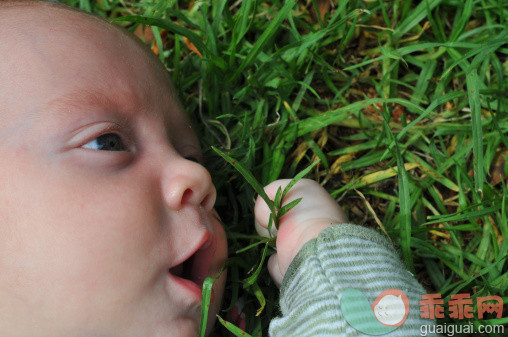 人,户外,人的脸部,白人,躺_143604085_Baby mouths fist of grass_创意图片_Getty Images China