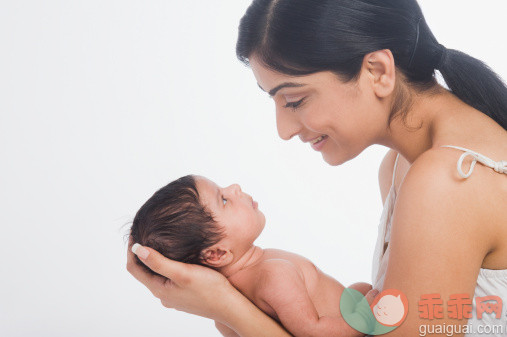 人,休闲装,室内,20到24岁,深情的_140833724_Woman carrying her baby and smiling_创意图片_Getty Images China