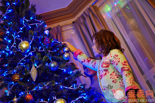 人,窗帘,二件式睡衣,室内,中长发_533676001_A young girl decorating a Christmas Tree_创意图片_Getty Images China