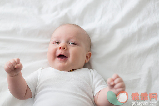 人,婴儿服装,床,室内,卧室_560140261_Portrait of happy baby laying on bed_创意图片_Getty Images China