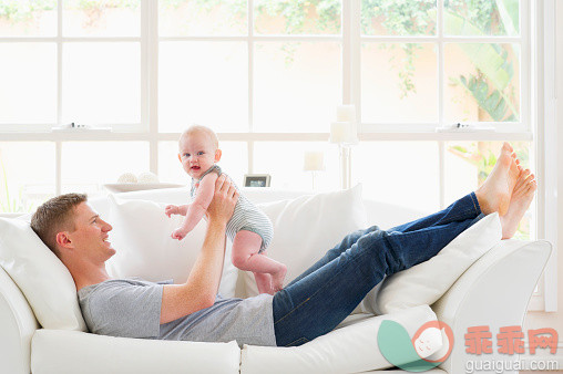 进行中,人,休闲装,沙发,2到5个月_565882257_Caucasian father playing with baby on sofa_创意图片_Getty Images China
