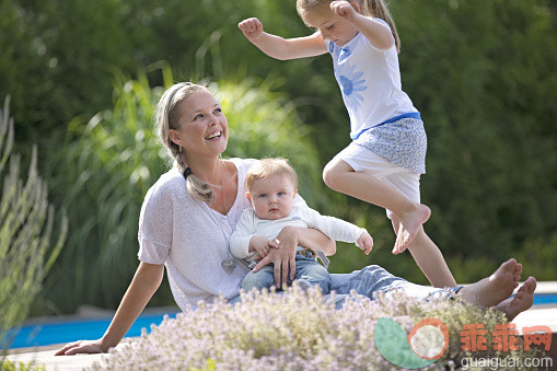 人,休闲装,生活方式,四分之三身长,户外_562481937_Mother holding baby son and watching daughter jump, outdoors_创意图片_Getty Images China