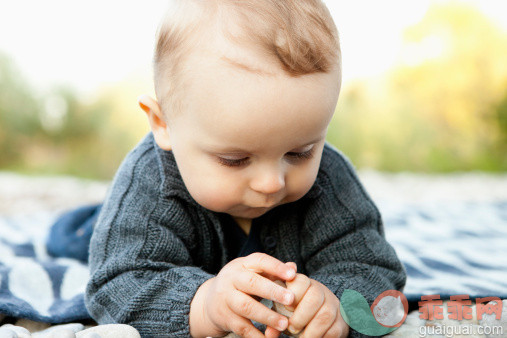 人,户外,白人,躺,毯子_127545616_Baby playing with pebbles outdoors_创意图片_Getty Images China