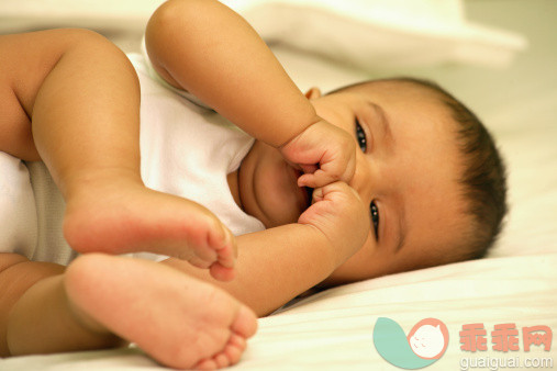 人,婴儿服装,室内,赤脚,躺_144462671_Close up of a baby playing_创意图片_Getty Images China