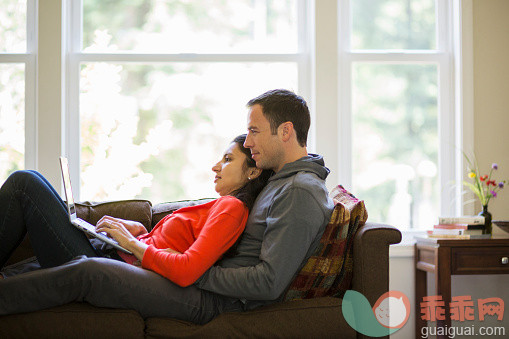 人,沙发,技术,四分之三身长,室内_562958083_Young couple cuddling on couch looking at laptop_创意图片_Getty Images China