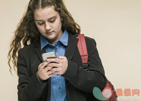 人,影棚拍摄,卷发,长发,金色头发_559329215_Female teenager in school uniform using mobile pho_创意图片_Getty Images China