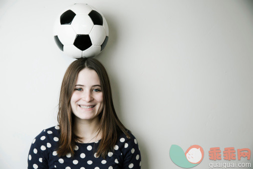 墙,人,休闲装,运动,影棚拍摄_494377063_Portrait of smiling teenage girl with football on her head in front of white wall_创意图片_Getty Images China