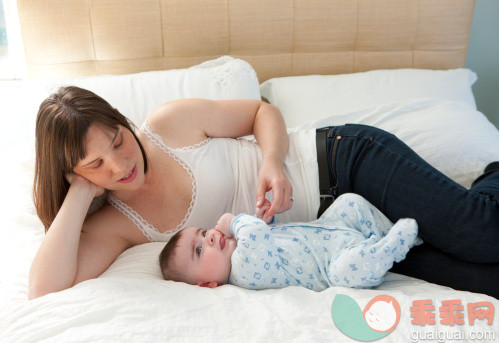 人,休闲装,床,连身衣,室内_113574031_Mom on bed holding her baby boy's hand._创意图片_Getty Images China