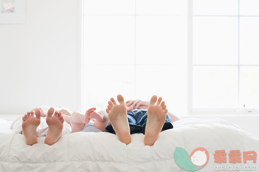 人,床,2到5个月,室内,腰部以下_565882277_Feet of Caucasian family laying on bed_创意图片_Getty Images China