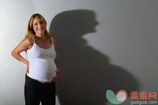 摄影,肖像,上装,室内,阴影_200147687-001_Pregnant woman holding her belly, portrait_创意图片_Getty Images China
