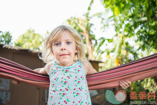 人,建筑结构,户外,吊床,蓝色眼睛_560338397_Girl in garden, arms wrapped around hammock_创意图片_Getty Images China