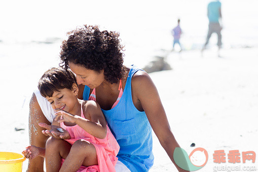 进行中,人,大桶,自然,度假_557474123_Mixed race mother and daughter playing on beach_创意图片_Getty Images China