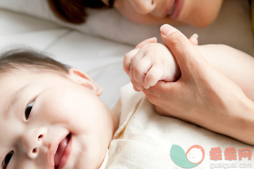 人,休闲装,床,室内,25岁到29岁_488609299_Mother holding baby's hand in bed_创意图片_Getty Images China