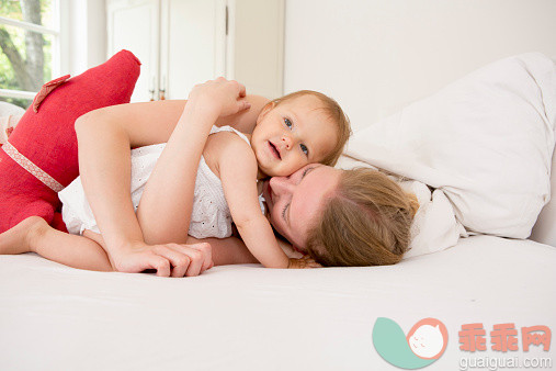 进行中,人,床,12到17个月,室内_525390119_Mother hugging baby daughter on bed_创意图片_Getty Images China