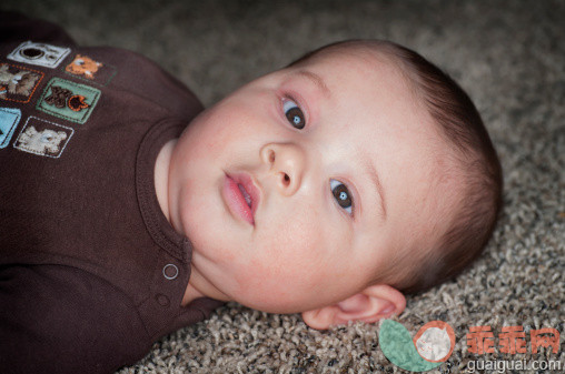 人,地毯,室内,褐色眼睛,棕色头发_484782173_Close-up of baby boy laying on the carpet._创意图片_Getty Images China