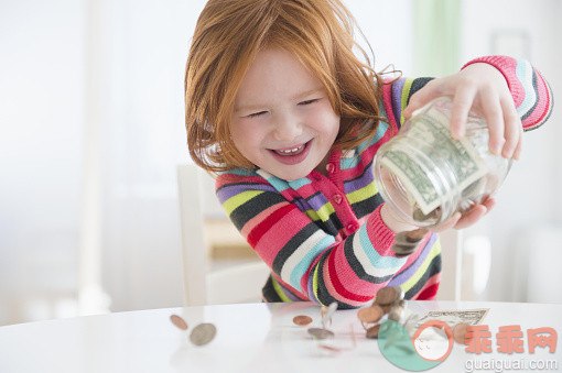 人,桌子,广口瓶,毛衣,金融_565974661_Caucasian girl pouring money from change jar_创意图片_Getty Images China