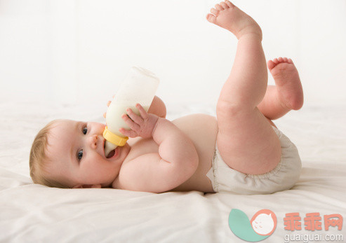 人,饮食,饮料,瓶子,影棚拍摄_138710428_Caucasian baby girl laying down drinking bottle_创意图片_Getty Images China