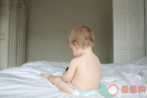 人,床,尿布,室内,金色头发_477355257_Portrait of baby sitting on a bed_创意图片_Getty Images China