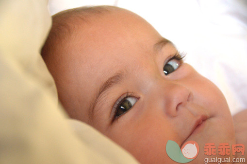 人,床,室内,人的头部,绿色眼睛_509695871_Baby girl lying on a pillow_创意图片_Getty Images China