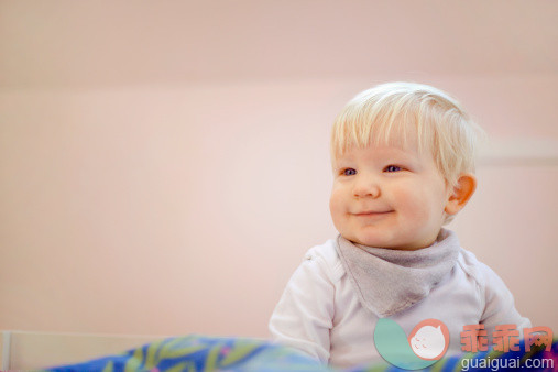 人,婴儿服装,住宅内部,毛衣,12到17个月_507850527_Portrait of cute fourteen month old baby boy sitting on duvet_创意图片_Getty Images China