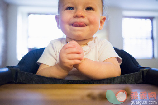 人,室内,白人,微笑,紧握双手_480984553_Toddler girl licking lips in highchair_创意图片_Getty Images China