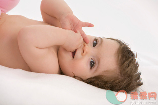 人,影棚拍摄,快乐,棕色头发,白人_153952862_Baby girl lying on back with finger in mouth, smiling_创意图片_Getty Images China