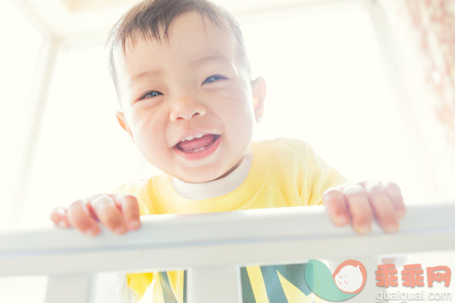 人,婴儿服装,室内,蓝色眼睛,棕色头发_169503903_The child leaning crib looking at the camera_创意图片_Getty Images China