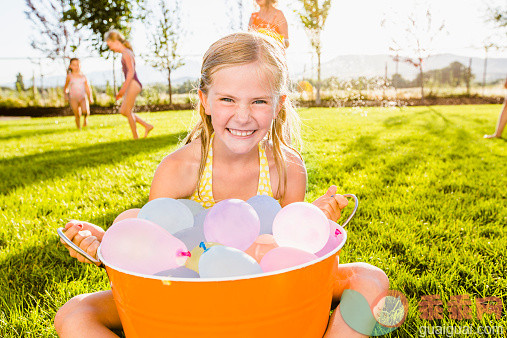 人,从容态度,气球,大桶,自然_514411219_Caucasian girl playing with water balloons in backyard_创意图片_Getty Images China