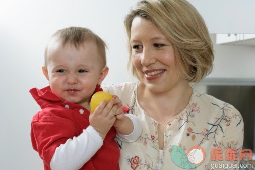 饮食,摄影,尝,家庭,头发长度_71242501_Mother carrying son on the arm, baby boy making face, holding a lemon_创意图片_Getty Images China