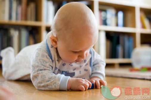 概念,主题,休闲活动,视角,构图_73347564_Baby boy (6-9 months) lying on wood floor playing with blocks_创意图片_Getty Images China