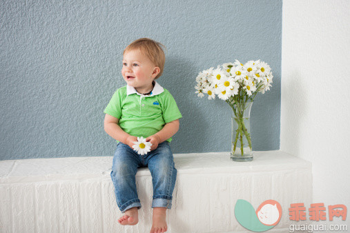 进行中,人,休闲装,婴儿服装,牛仔裤_485206091_Baby boy playing with flowers_创意图片_Getty Images China