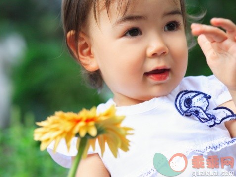 概念,视角,构图,图像,摄影_74227675_Close-up of a baby girl holding a gerbera daisy_创意图片_Getty Images China