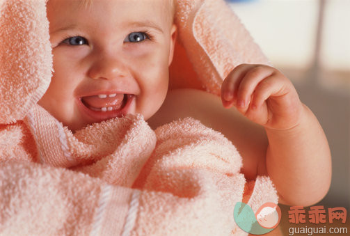 美,身体保养,摄影,室内,人的嘴_ab21938_Baby (6-9 months) wrapped in towel smiling, close-up_创意图片_Getty Images China