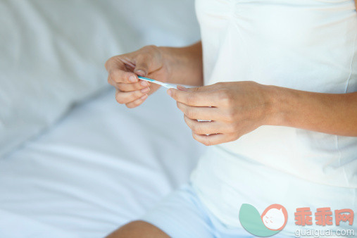 人,休闲装,床,健康保健,室内_149285609_Woman holding pregnancy test, mid section_创意图片_Getty Images China