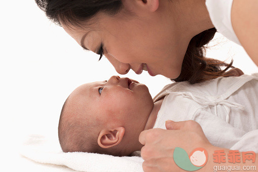 人,休闲装,婴儿服装,2到5个月,影棚拍摄_558981245_Young woman looking down and smiling at baby girl_创意图片_Getty Images China