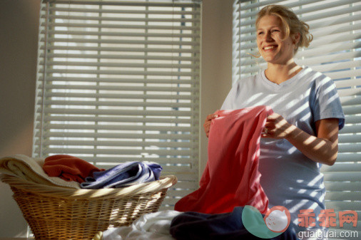 家庭生活,家常杂务,家务,人生大事,摄影_57572085_Pregnant woman folding clothes_创意图片_Getty Images China