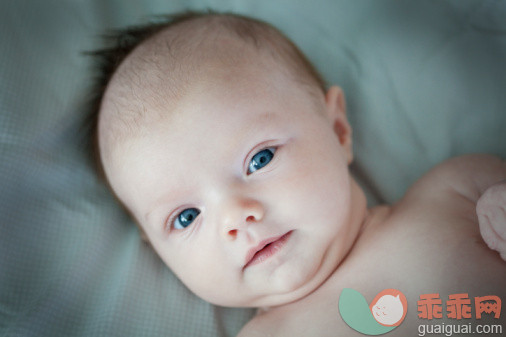 人,室内,蓝色眼睛,白人,微笑_102622180_Portrait of baby lying on bed_创意图片_Getty Images China