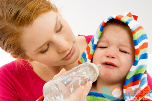 人,衣服,生活方式,室内,冷饮_82115220_Close-up of a young woman feeding from a baby bottle to her crying son_创意图片_Getty Images China
