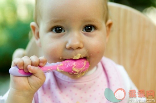 人,食品,银餐具,室内,汤匙_91627200_Baby girl holding spoon of baby food to her mouth, looking at camera_创意图片_Getty Images China