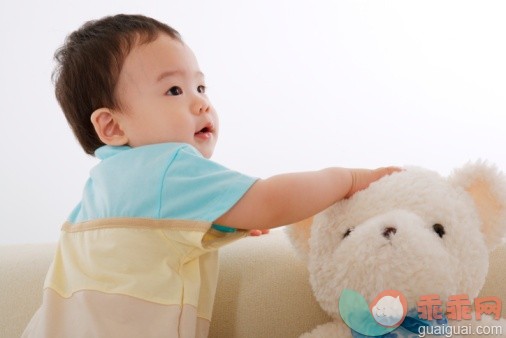 概念,构图,图像,摄影,肖像_77060858_Baby boy on sofa touching teddy bear looking away_创意图片_Getty Images China
