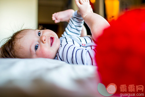 人,2到5个月,室内,白昼,奥克兰_559321549_A baby girl playing on a white bed spread indoors_创意图片_Getty Images China