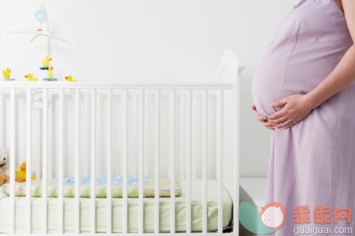 家庭生活,Y50624,摄影,婴儿用品,婴儿床_200193087-001_Pregnant woman standing beside crib, mid section, side view_创意图片_Getty Images China