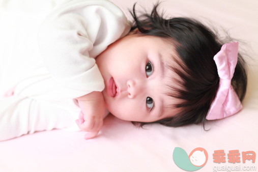 人,婴儿服装,床,室内,黑发_158900493_Baby Girl with a Pink Ribbon bow_创意图片_Getty Images China