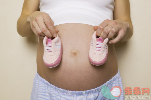 人生大事,摄影,Y51111,室内,鞋子_55965002_Mid section view of a pregnant woman holding a pair of shoes_创意图片_Getty Images China